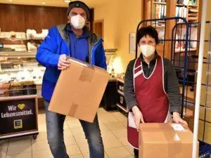 Frau und Mann mit Maske und Paket