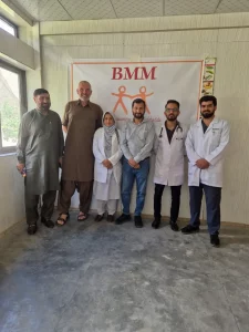 Sechs Personen stehen vor einem Plakat für das BMM Medical Camp