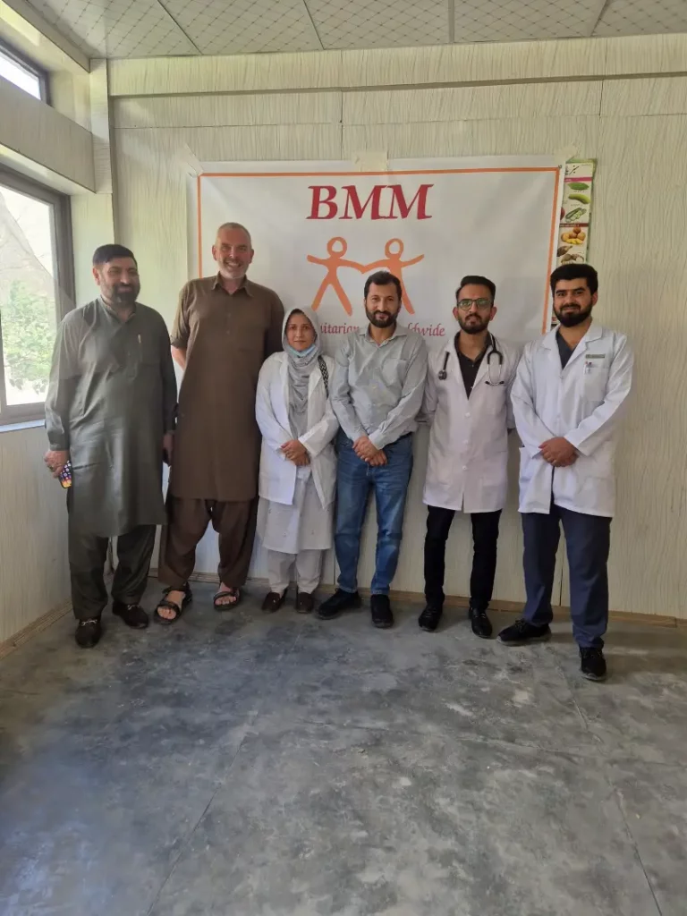 Sechs Personen stehen vor einem Plakat für das BMM Medical Camp